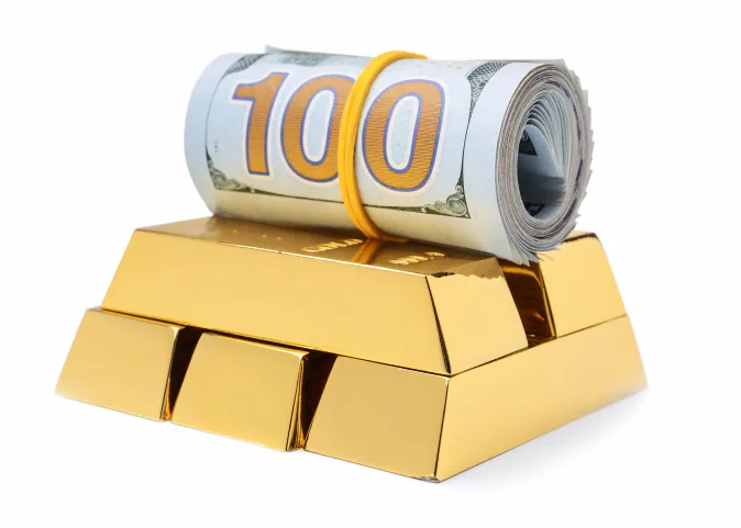 A roll of dollars on gold bars